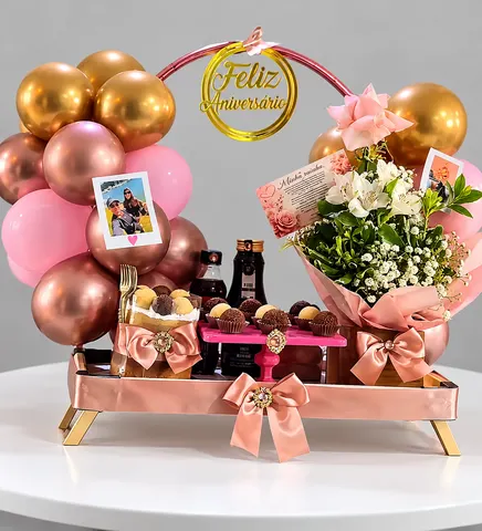 Cesta Happy Fest: bandeja rosé com arco de balões rosê e dourados, Feliz Aniversário, brigadeiros, cake, fotos polaroide e buquê de flores